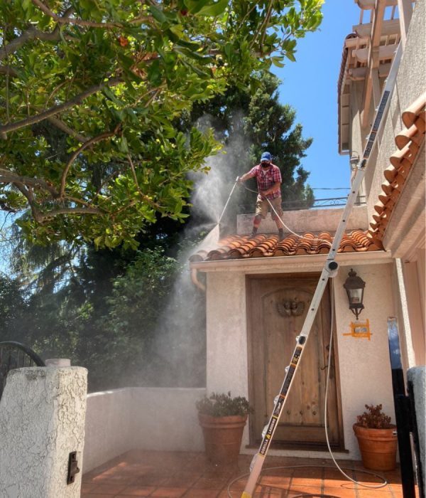 Big Wave Window service professional pressure washing a roof