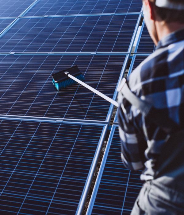 A closeup of a Big Wave Window professional scrubbing solar panels